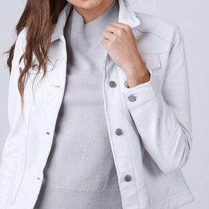 May include: A white denim jacket with a button-up front and long sleeves. The jacket has a classic style and is made of a soft, comfortable material.