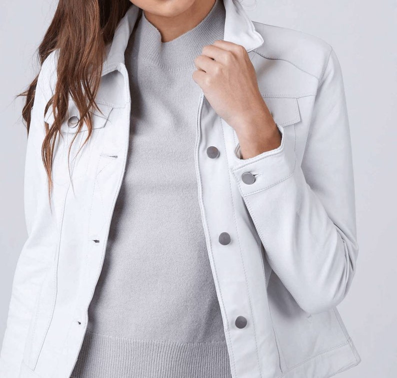 May include: A white denim jacket with a button-up front and long sleeves. The jacket has a classic style and is made of a soft, comfortable material.