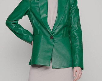 May include: A vibrant green blazer with a single-button closure. The jacket features a classic lapel design and is paired with a neutral-toned dress. The blazer's color is a bold, eye-catching shade.