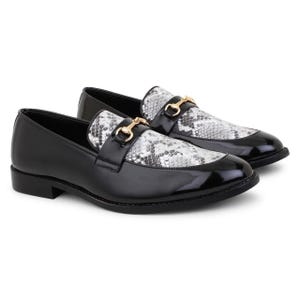 Peut inclure: Mocassins en cuir noir avec un motif en peau de serpent sur la pointe et une boucle dorée.