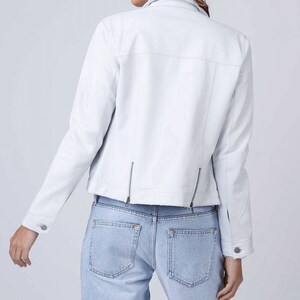 May include: A white leather jacket with a zipper closure and a slightly cropped hem.
