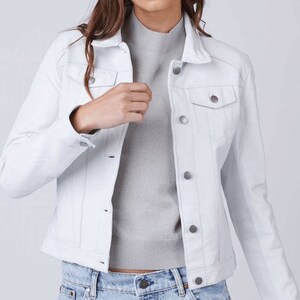 May include: A white denim jacket with a button closure and two front pockets.