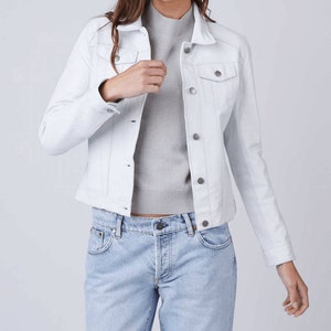 May include: A white denim jacket with a classic design. The jacket has a button-up front, two chest pockets, and long sleeves.