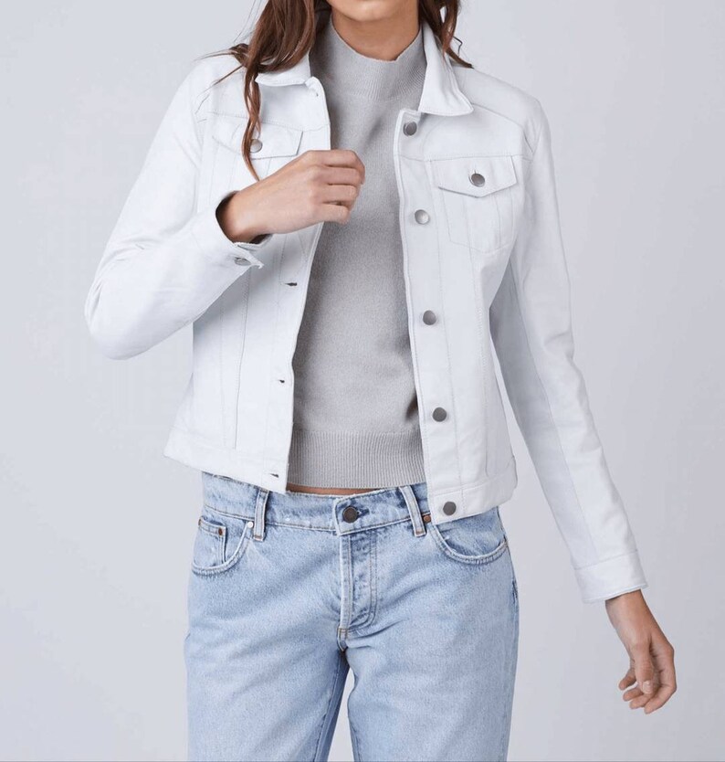 May include: A white denim jacket with a classic design. The jacket has a button-up front, two chest pockets, and long sleeves.