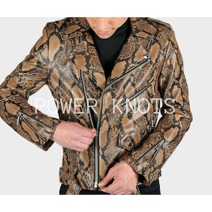 May include: A brown and black snakeskin-patterned leather jacket with a zipper closure and a belt. The jacket has a zippered pocket on the left side and a zippered pocket on the right side.