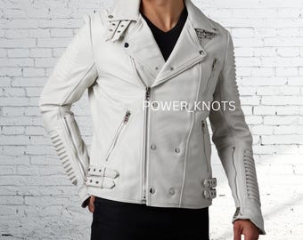 Puede incluir: Chaqueta de cuero blanca de estilo motero con diseño cruzado, con múltiples cremalleras, hebillas y costuras decorativas. La chaqueta tiene un cuello con solapas y el texto "POWER_KNOTS" es visible.