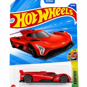 Peut inclure: Un véhicule miniature Hot Wheels Cadillac Project GTP Hypercar rouge dans son emballage blister bleu et jaune d'origine. L'emballage présente le logo Hot Wheels, le texte 99/250, 1/5 Exotics et le nom de la voiture en bas de la carte.