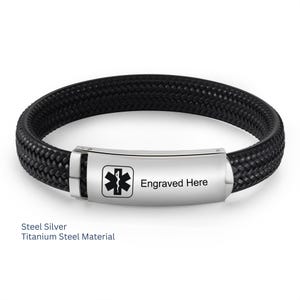 Könnte beinhalten: Schwarz geflochtenes Armband mit silbernem Verschluss. Der Verschluss zeigt das medizinische Symbol Star of Life und den Text "Engraved Here". Das Armband besteht aus Stahl und Titan.