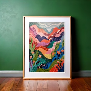 Pode incluir: Pintura abstrata de paisagem com colinas coloridas, flores e folhagem. A pintura é emoldurada em uma moldura de madeira clara.