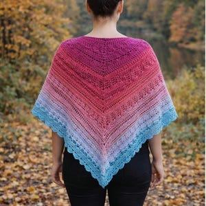 May include: A triangular crochet shawl featuring a vibrant gradient color transition from deep magenta at the top to soft pink, light purple, and finally a bright blue scalloped edge at the bottom, showcasing intricate openwork stitch patterns.