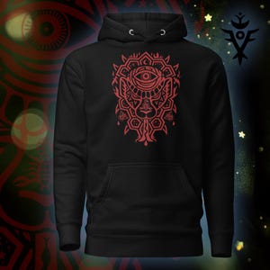 Può includere: Felpa con cappuccio nera con un design grafico rosso sul davanti. Il design presenta un occhio, forme geometriche e un volto stilizzato. La felpa ha un cappuccio con coulisse e una tasca a marsupio.