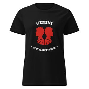 May include: Black t-shirt with a red Gemini design, featuring two profiles and the words "GEMINI" and "SOCIAL BUTTERFLY". The design includes star accents. A casual tee for astrology fans.