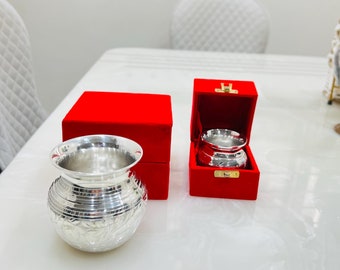 May include: Two silver, engraved, decorative containers with lids, one in a red velvet box and one out of the box, on a white surface.