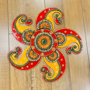 Könnte beinhalten: Ein dekoratives Mandala in Rot, Gelb und Grün mit komplizierten Mustern und Verzierungen. Das Mandala ist aus Holz und hat eine kreisförmige Form.