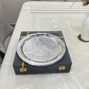 May include: A silver serving tray with an intricate floral design, presented in a dark gray box with gold accents.