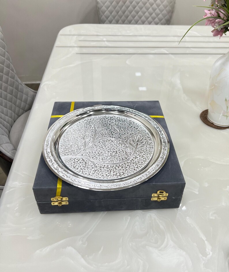May include: A silver serving tray with an intricate floral design, presented in a dark gray box with gold accents.