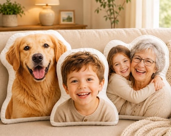 May include: Three custom-shaped throw pillows featuring high-resolution photographic prints. One pillow displays a golden retriever, one shows a young child smiling, and one depicts a child embracing an older adult with glasses.