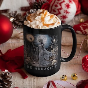 May include: Black coffee mug with a white rim and handle. The mug features a black and white illustration of a skeletal figure in a forest setting with the text "With the Audacity".