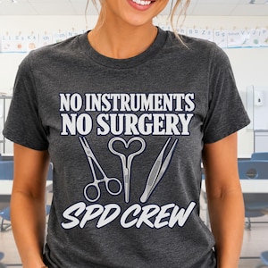 May include: A dark charcoal gray short-sleeve t-shirt featuring white text that reads NO INSTRUMENTS NO SURGERY SPD CREW. The graphic includes illustrations of surgical scissors, a hemostat, and tweezers centered between the lines of text.