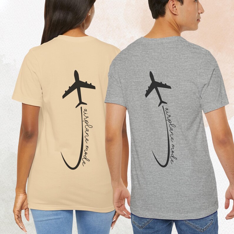 May include: Two t-shirts with a black airplane graphic and the text "airplane mode" written in a cursive font. The t-shirts are in different colors, one is beige and the other is gray.