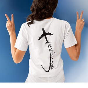 May include: White t-shirt with a black airplane graphic and the text "airplane mode" written vertically along the side of the airplane.