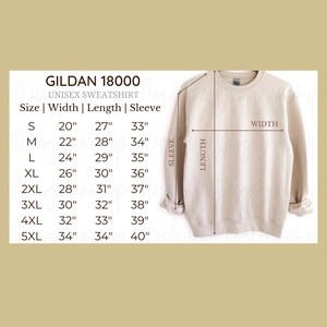 May include: A beige Gildan 18000 unisex sweatshirt with size chart. The chart shows measurements for width, length, and sleeve length in inches, ranging from size S to 5XL. The sweatshirt is displayed with arrows indicating width, length, and sleeve.