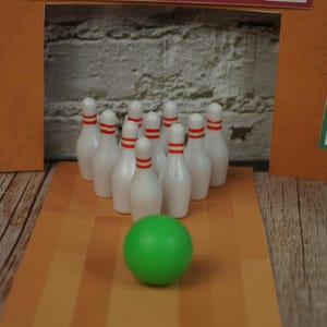 May include: A miniature bowling set with white pins and a green ball. The pins have red stripes near the top. The set is arranged on a lane with orange and brown stripes, with a brick wall in the background. A sign that says "Strike" is on the right.