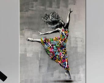May include: A canvas print featuring a dancer in mid-air. The dancer wears a colorful dress adorned with graffiti-style art. The background is a textured gray, and the dancer's hair is flowing. The artwork is a modern, artistic representation.