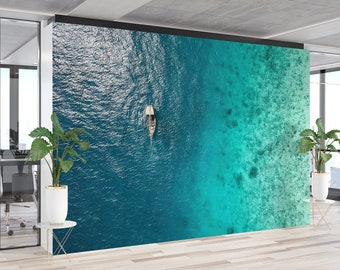May include: An office interior with a large wall mural depicting an aerial view of a boat sailing on a turquoise ocean with a coral reef in the background.