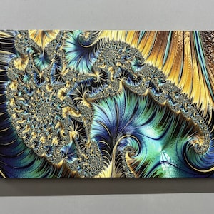 Op de afbeelding: Abstracte kunstprint met een draaiend patroon in blauwe, groene en gouden kleuren. Het ontwerp lijkt op een fractal of een natuurlijk patroon zoals een schelp.