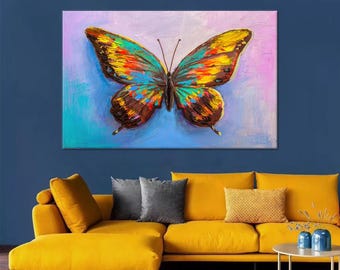 May include: A large, colorful butterfly painting with a vibrant palette of blues, yellows, oranges, and browns. The artwork is displayed above a yellow sectional sofa, creating a striking contrast against the deep blue wall.