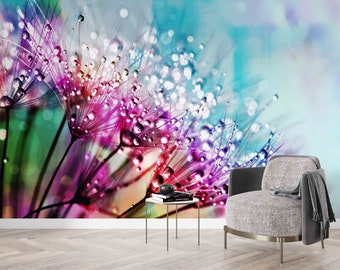 May include: A close-up of a dandelion seed head with water droplets, creating a colorful and abstract image. The background is a soft blue and purple gradient.