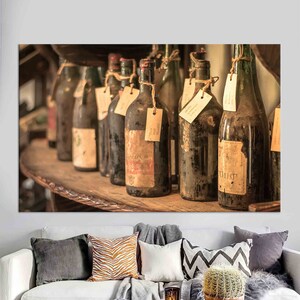以下が含まれることがあります： 木製の棚に、手書きのラベルが貼られた、埃っぽいワインボトルが並んでいます。ボトルは茶色と緑の様々な色合いで、中にはコルク栓のものもあります。