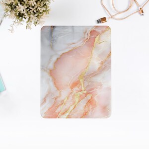 May include: Pink and white marble pattern with gold veins. The marble pattern is on a phone case.