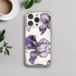 Può includere: Una custodia per telefono trasparente con un design floreale con iris viola su sfondo bianco.