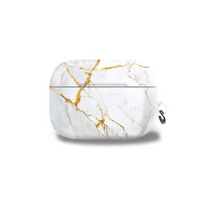 May include: White and gold marble-patterned case for wireless earbuds. The case has a smooth, rounded design with a gold veining pattern. A small black carabiner clip is attached to the side. The case is designed to protect and carry earbuds.