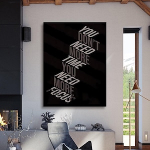 Könnte beinhalten: Motivierender Leinwanddruck mit dem Text "YOU DON'T NEED MORE TIME YOU NEED MORE FOCUS" in weißer und grauer Schrift auf schwarzem Hintergrund mit diagonalen Streifen. Das Kunstwerk wird in einem modernen Wohnzimmer präsentiert.