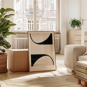 Może przedstawiać: Wydruk abstrakcyjnej sztuki w ramie z czarnymi i beżowymi kształtami geometrycznymi. Wydruk nosi tytuł "La Collection".