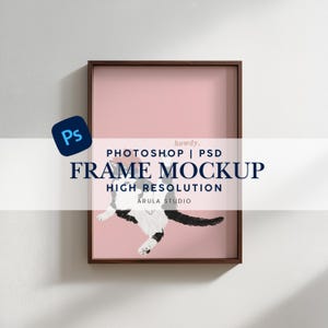 Könnte beinhalten: Gerahmter Kunstdruck mit einer schwarz-weißen Katzenillustration auf rosa Hintergrund. Der Rahmen ist dunkelbraun. Der Text auf dem Druck lautet "Photoshop | PSD Frame Mockup High Resolution" und "howdy."
