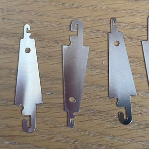 May include: Five silver thread loopers, each with a different shape and size, for threading yarn through small spaces.