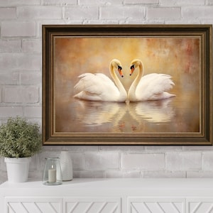 May include: A framed print of two white swans with their necks intertwined in the shape of a heart, set against a soft, golden background.