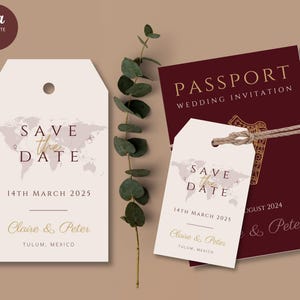 May include: Two save the date cards featuring a world map design with the text "Save the Date" in gold lettering. The cards are tied with twine and display the date "14th March 2025" and the names "Claire & Peter". The cards are placed against a brown background with a sprig of greenery.