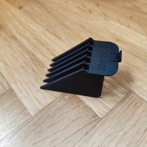 May include: Black plastic hair clipper guard with a 3mm length setting.