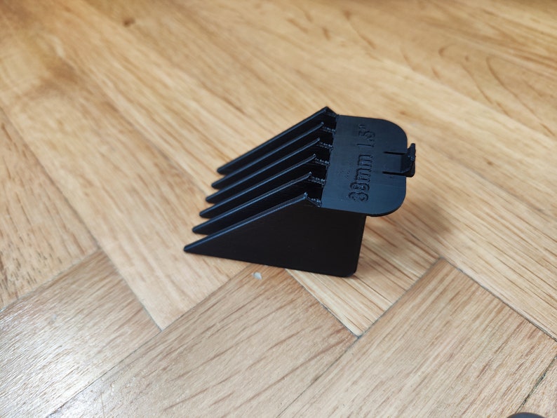 May include: Black plastic hair clipper guard with a 3mm length setting.