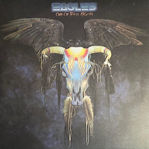 May include: Album cover for the Eagles' "One of These Nights." The artwork features a stylized skull with horns, feathers, and wings against a dark background. The band's name and album title are at the top.