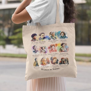 Op de afbeelding: Een beige tote bag met een kleurrijke illustratie van vrouwen in de wetenschap. De tas toont portretten van 12 vrouwelijke wetenschappers, waaronder Marie Curie, Jane Goodall en Valentina Tereshkova. De tekst "Women in Science" staat onderaan de tas gedrukt.