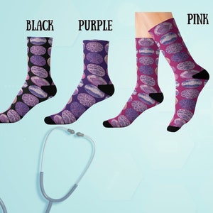 May include: Three pairs of socks with a purple and pink patterned design. The socks are labeled "Black", "Purple", and "Pink".