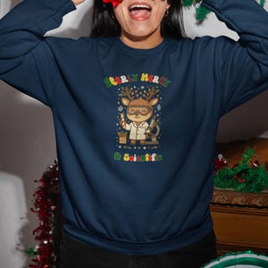 Peut inclure: Sweat-shirt bleu marine avec un motif de renne de Noël portant des lunettes et une blouse de laboratoire. Le texte dit "Deerly Merry & Scientific". Idéal pour les fêtes de fin d'année.