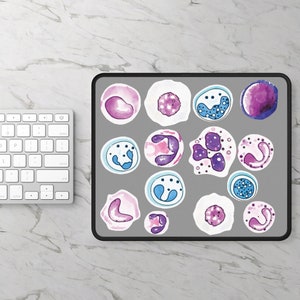 Könnte beinhalten: Graues Mauspad mit Aquarellillustrationen verschiedener Zellen in Lila-, Blau- und Weißtönen. Das Mauspad hat einen schwarzen Rand und befindet sich neben einer weißen Tastatur auf einer Marmoroberfläche.
