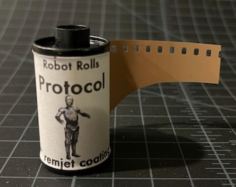 May include: A roll of 35mm film with a label that says "Robot Rolls Protocol" and features a robot character. The label also says "remjet coating".